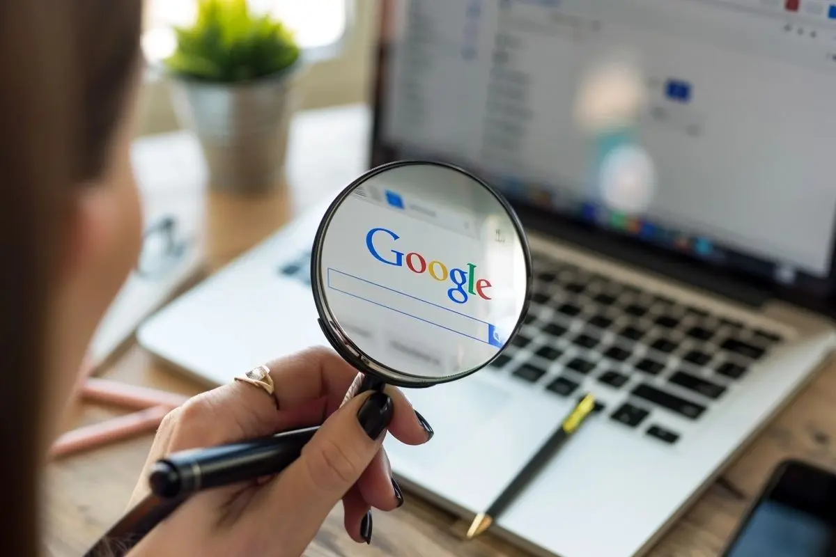 Ilustração do mascote da Seu Espaço Web segurando uma lupa, representando busca no Google